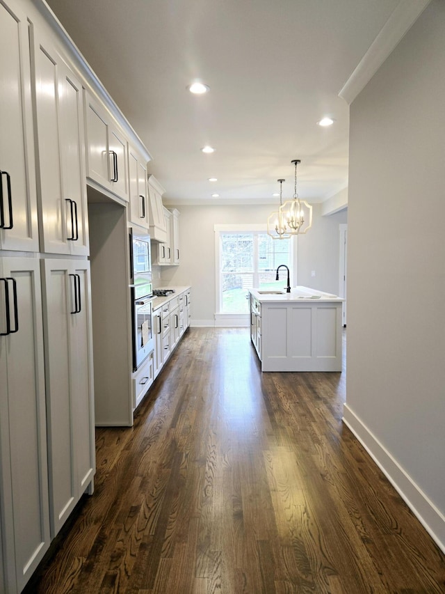 kitchen with white cabinets, an island with sink, and oven