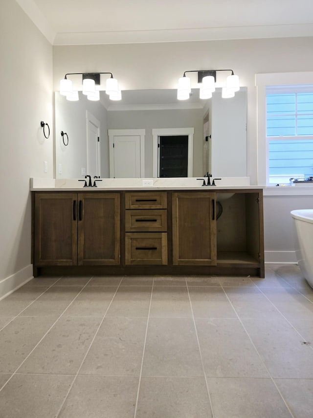 bathroom with tile patterned flooring, vanity, crown molding, and a bath