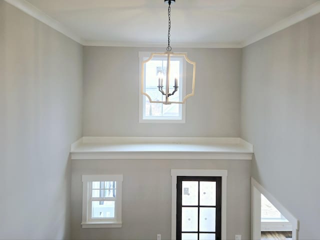 entryway with a notable chandelier and ornamental molding