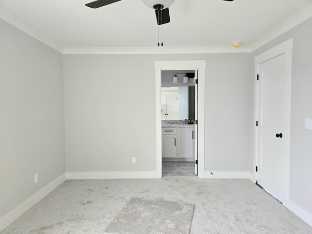 unfurnished bedroom with light carpet, ensuite bathroom, ceiling fan, and crown molding