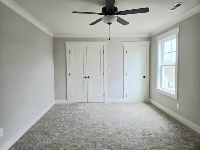 unfurnished bedroom with ceiling fan, carpet, and ornamental molding