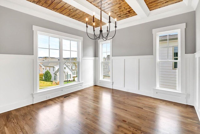 unfurnished dining area featuring visible vents, wooden ceiling, beamed ceiling, wood finished floors, and an inviting chandelier