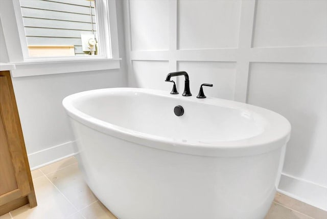 full bathroom with a freestanding tub and tile patterned floors