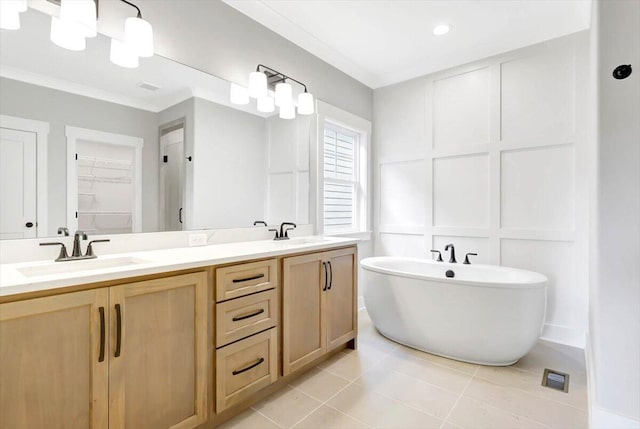 bathroom with double vanity, a soaking tub, a sink, and a decorative wall