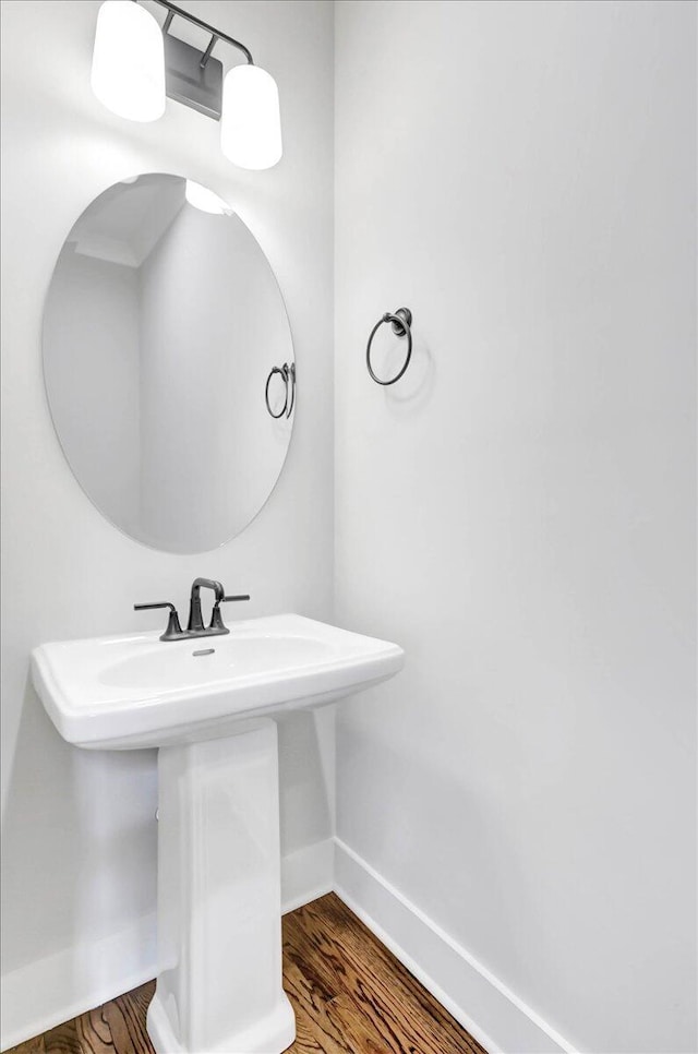 bathroom featuring a sink, baseboards, and wood finished floors