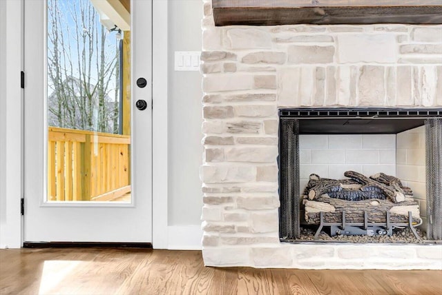 details featuring a fireplace, baseboards, and wood finished floors