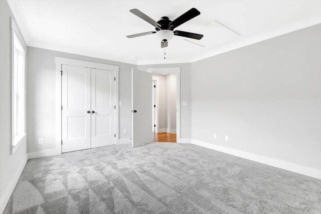 unfurnished bedroom with a ceiling fan, a closet, light carpet, and baseboards