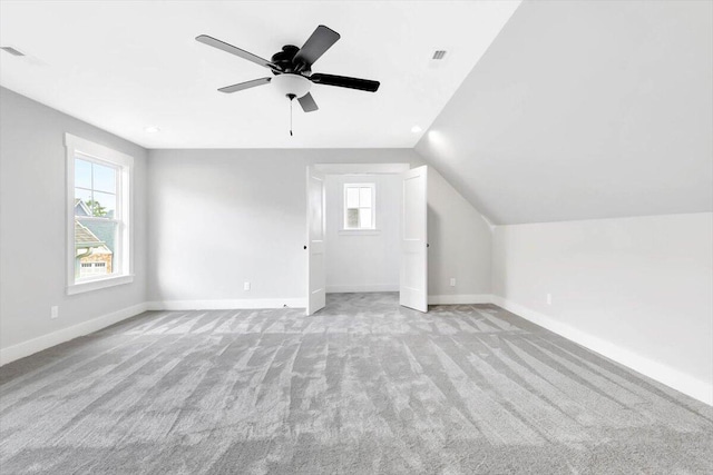 bonus room featuring lofted ceiling, visible vents, light carpet, and baseboards