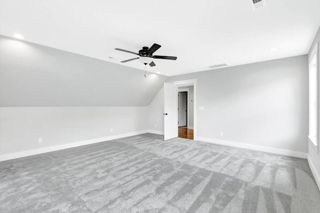 bonus room featuring visible vents, a ceiling fan, light carpet, vaulted ceiling, and baseboards