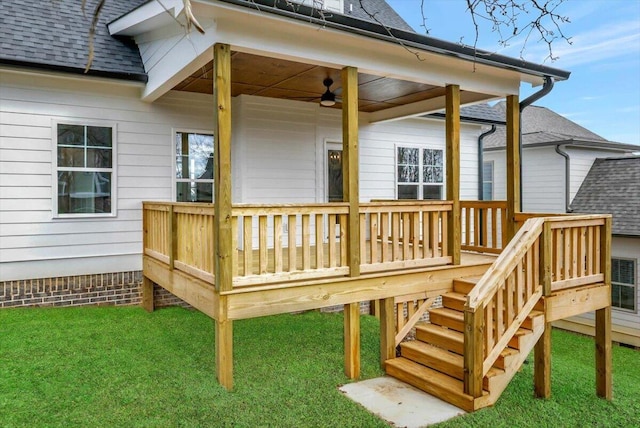 wooden terrace featuring stairs, a ceiling fan, and a yard