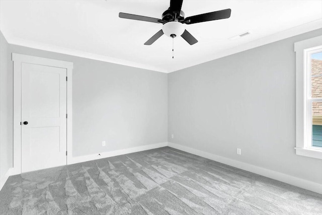 empty room featuring light carpet, ceiling fan, ornamental molding, and baseboards