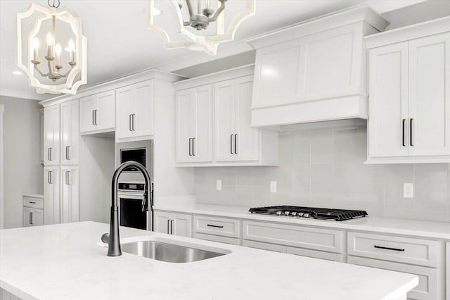 kitchen with light countertops, hanging light fixtures, an inviting chandelier, and white cabinets