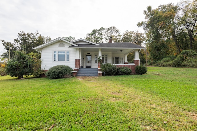 ranch-style house featuring a front yard and covered porch