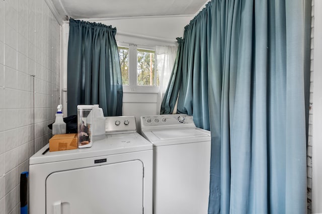 laundry area with tile walls and washing machine and clothes dryer