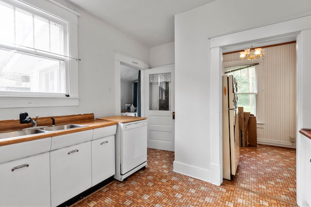 kitchen with sink, pendant lighting, an inviting chandelier, white cabinetry, and white appliances