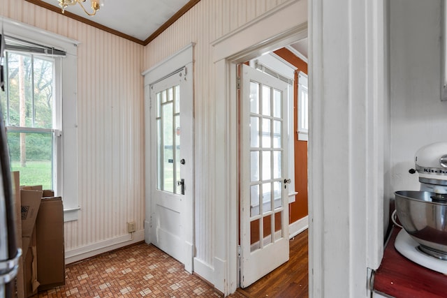 entryway with crown molding, a notable chandelier, and dark hardwood / wood-style flooring