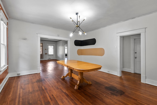 unfurnished dining area featuring crown molding, a notable chandelier, and dark hardwood / wood-style flooring