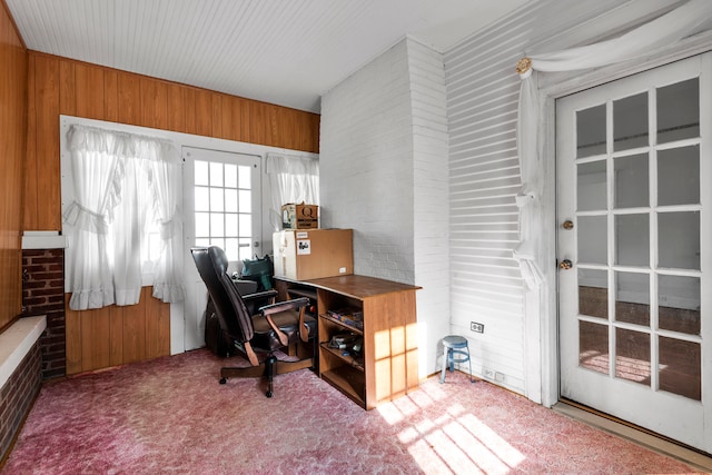 carpeted office featuring wood walls