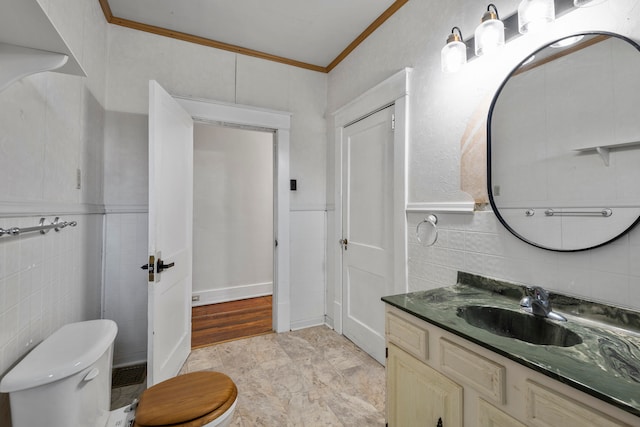 bathroom featuring tile walls, vanity, crown molding, and toilet