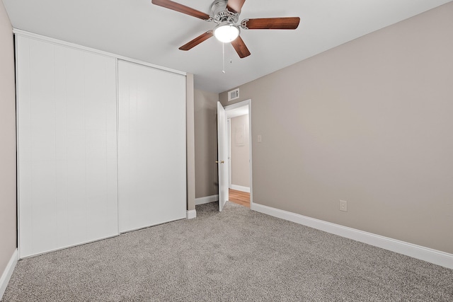 unfurnished bedroom with carpet, a closet, and ceiling fan