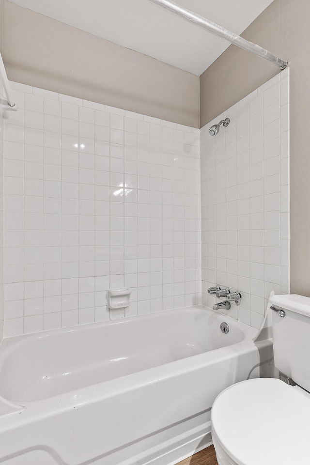 bathroom with toilet and tiled shower / bath combo