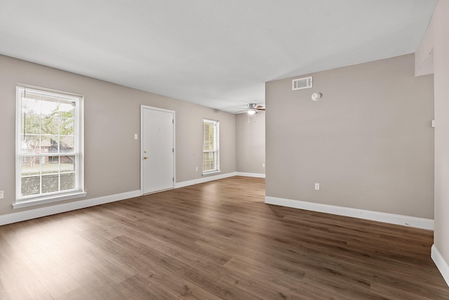 unfurnished room with dark hardwood / wood-style flooring, ceiling fan, and a wealth of natural light