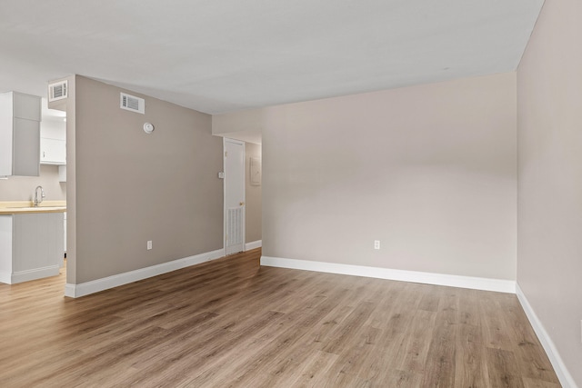 empty room with sink and light hardwood / wood-style flooring