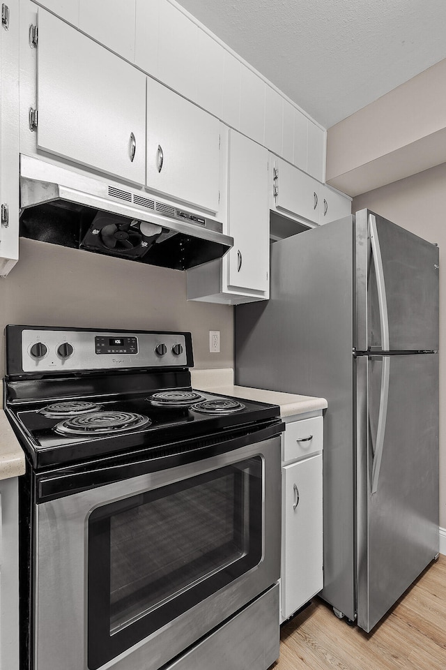 kitchen with stainless steel appliances, light hardwood / wood-style flooring, and white cabinets