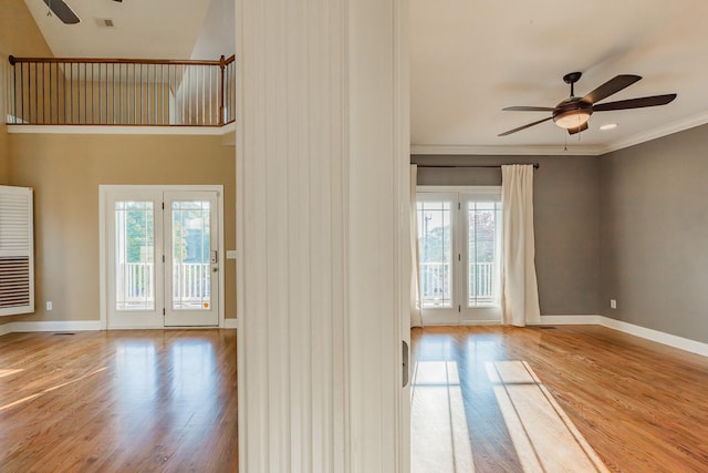 entrance foyer featuring french doors, ceiling fan, crown molding, and light wood-type flooring