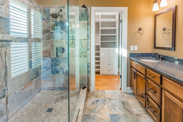 bathroom featuring vanity, hardwood / wood-style flooring, and a shower with door