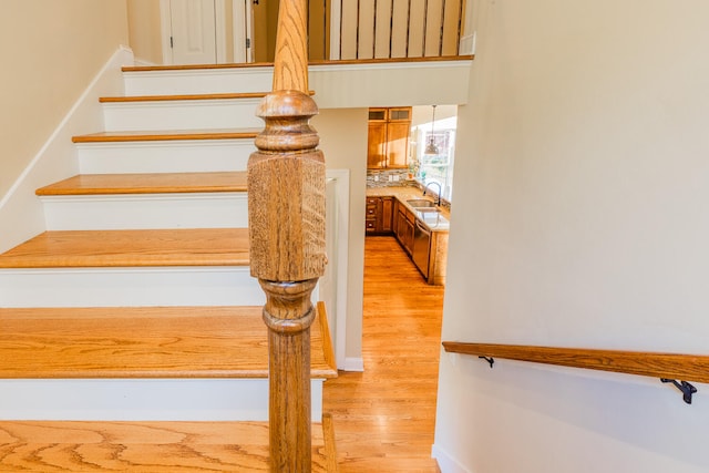 stairway with sink and wood-type flooring