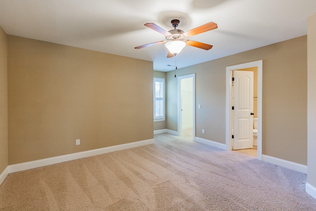 spare room featuring light carpet and ceiling fan