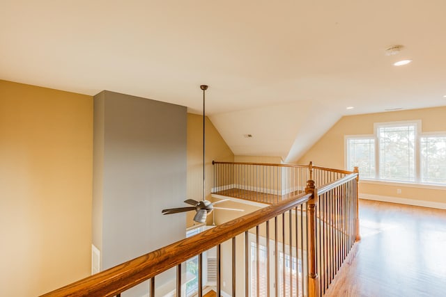 hall with lofted ceiling and hardwood / wood-style flooring