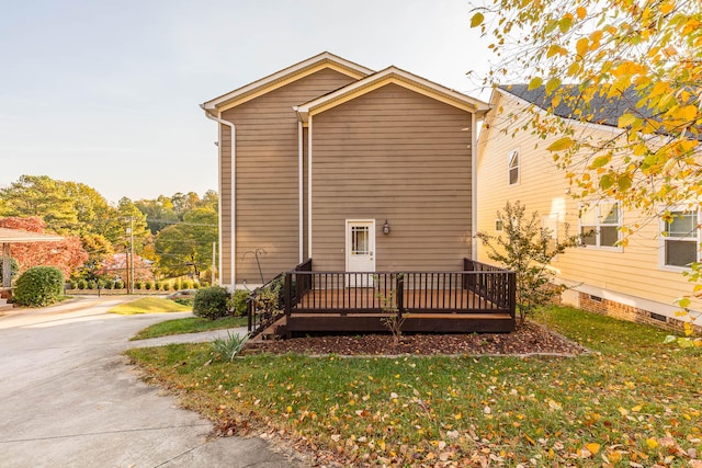 view of side of property with a wooden deck and a lawn