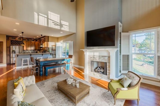 living room with hardwood / wood-style floors and a towering ceiling