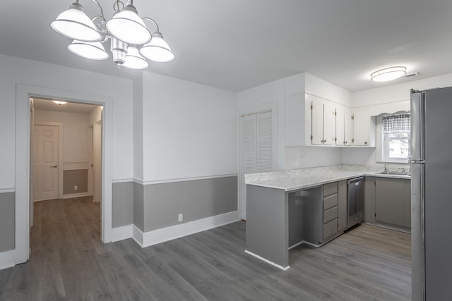 kitchen featuring refrigerator, sink, stainless steel dishwasher, dark hardwood / wood-style floors, and kitchen peninsula