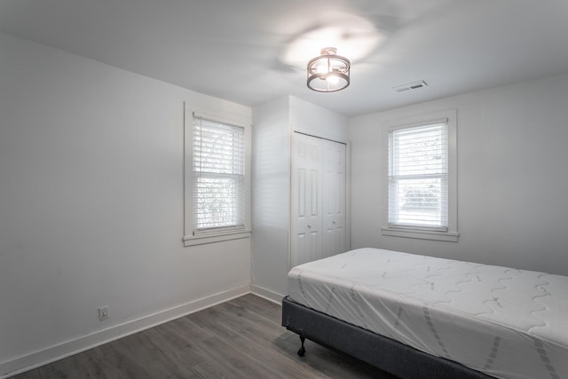 bedroom with dark hardwood / wood-style floors and a closet