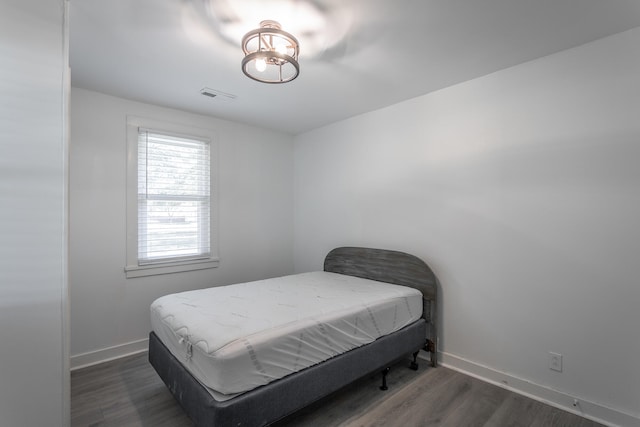 bedroom with dark wood-type flooring