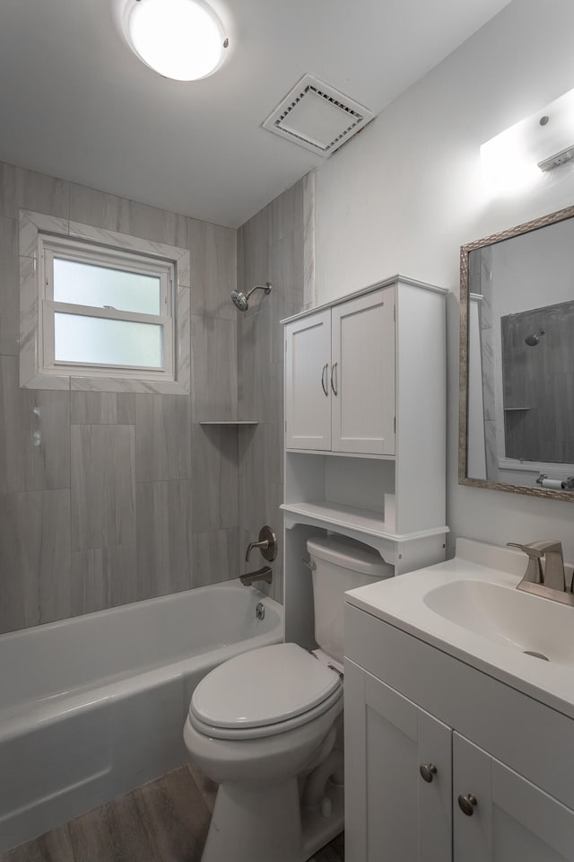 full bathroom with vanity, wood-type flooring, tiled shower / bath combo, and toilet