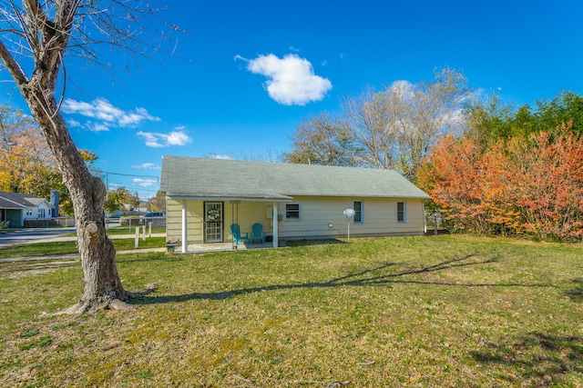 rear view of house featuring a lawn