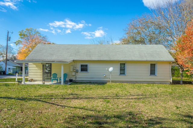 rear view of property with a patio and a lawn