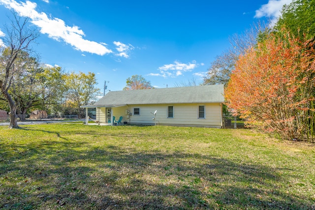 rear view of property featuring a lawn