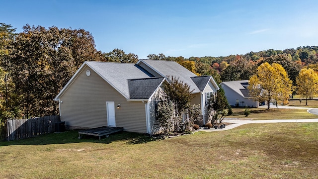 view of side of home with a yard and central AC unit