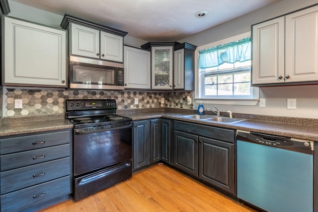 kitchen with backsplash, stainless steel appliances, light hardwood / wood-style flooring, and sink