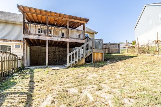 rear view of property with a yard and a wooden deck