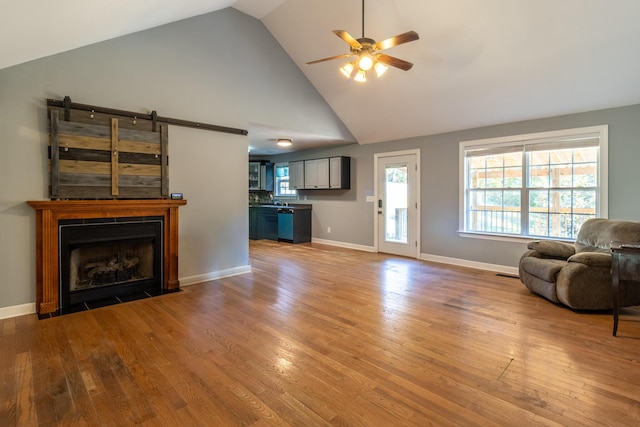 living room featuring ceiling fan, sink, high vaulted ceiling, and hardwood / wood-style flooring