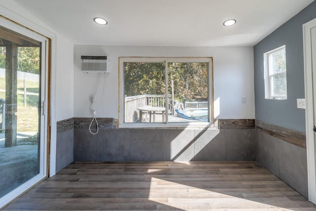 unfurnished room featuring a wall mounted AC and dark hardwood / wood-style floors