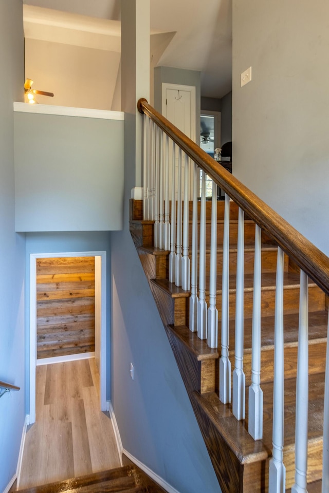 staircase featuring ceiling fan and hardwood / wood-style flooring