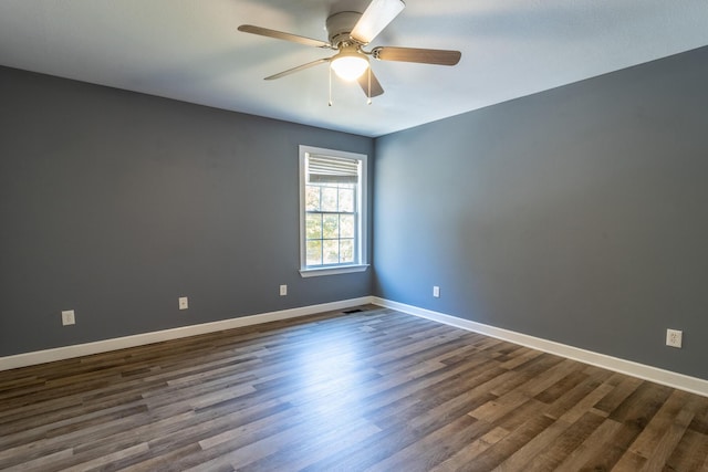 unfurnished room with ceiling fan and dark wood-type flooring