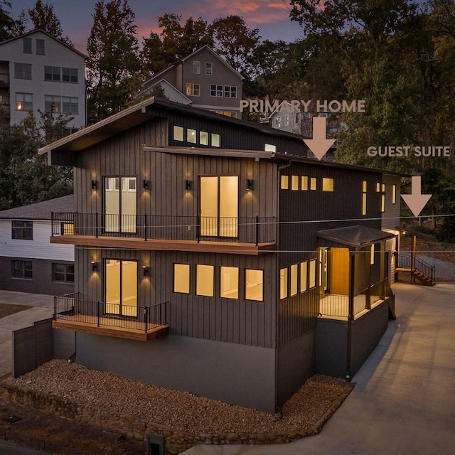 back house at dusk featuring a balcony